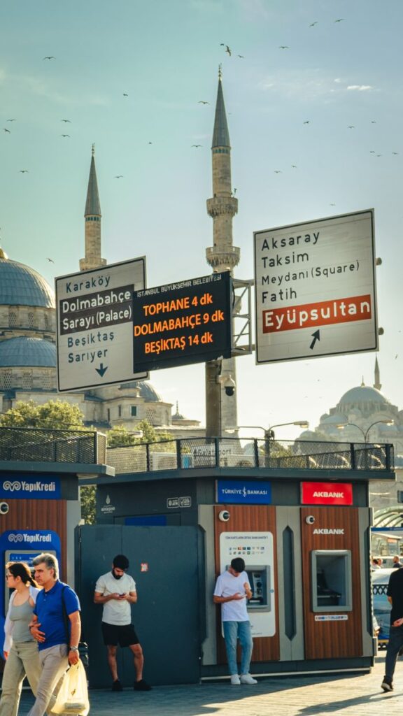 Bustling street view with people and signs near a mosque in Istanbul, Turkey.